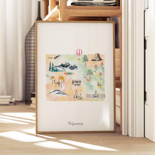 A framed watercolor painting depicting various scenes and landmarks of Wyoming, including mountains, wildlife, and buildings.