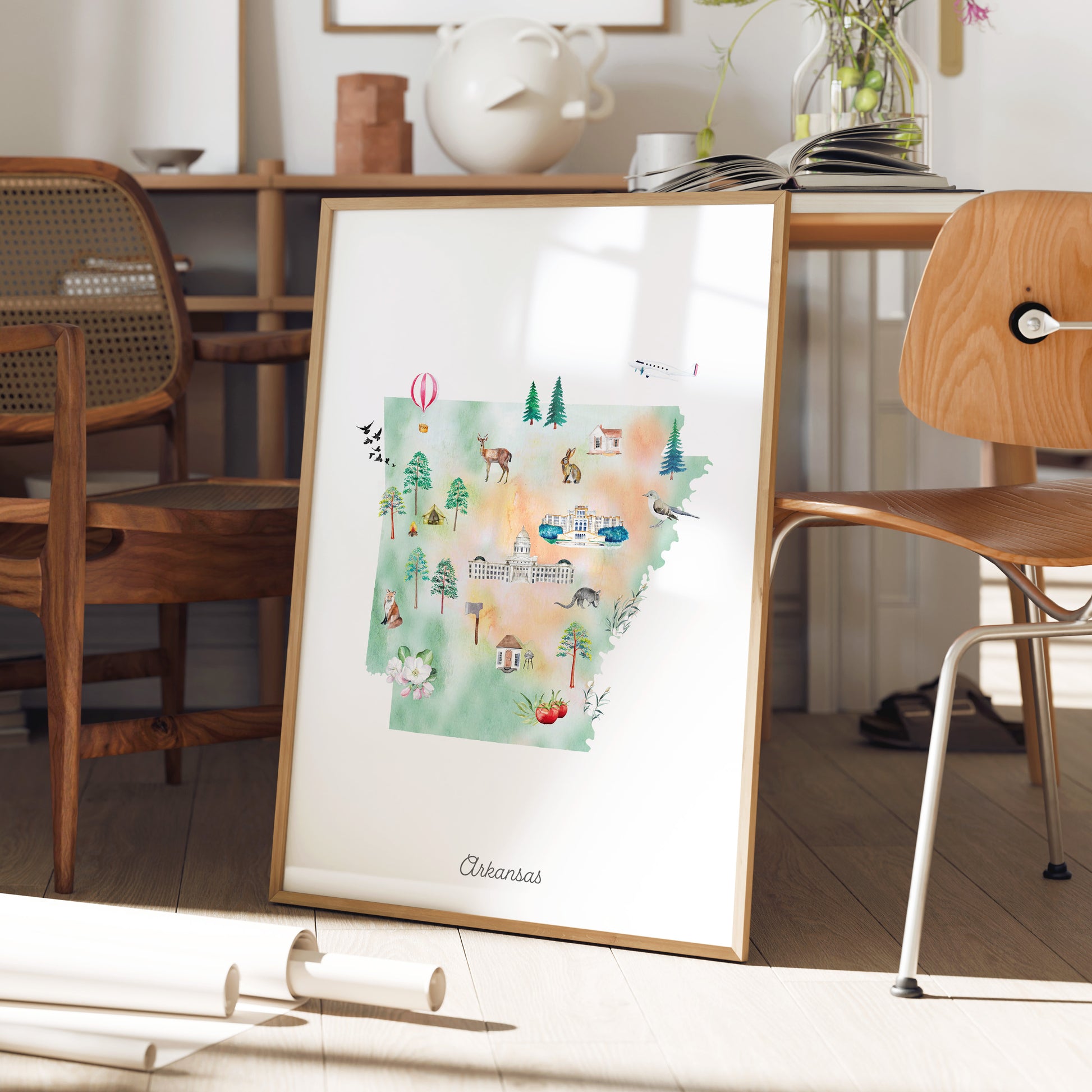 a framed illustration of a map of Arkansas, with various landmarks and symbols representing different regions within the state.