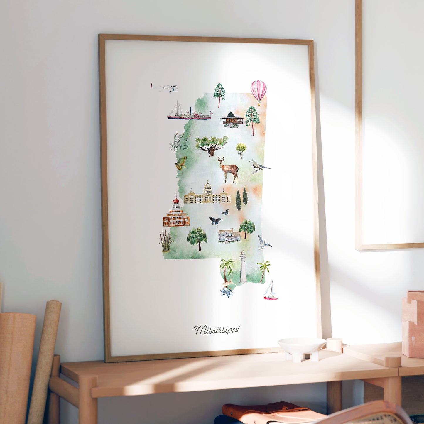 a framed watercolor illustration of the state of Mississippi, depicting various landmarks and scenes from the state.