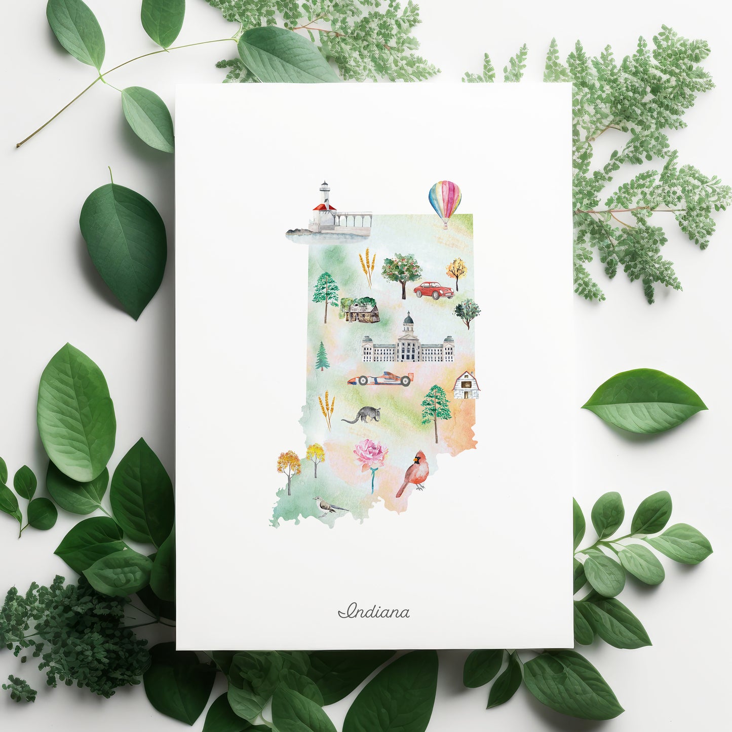 The image is a watercolor illustration of the state of Indiana, surrounded by green leaves and flowers.