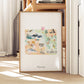 A framed watercolor painting depicting various scenes and landmarks of Wyoming, including mountains, wildlife, and buildings.