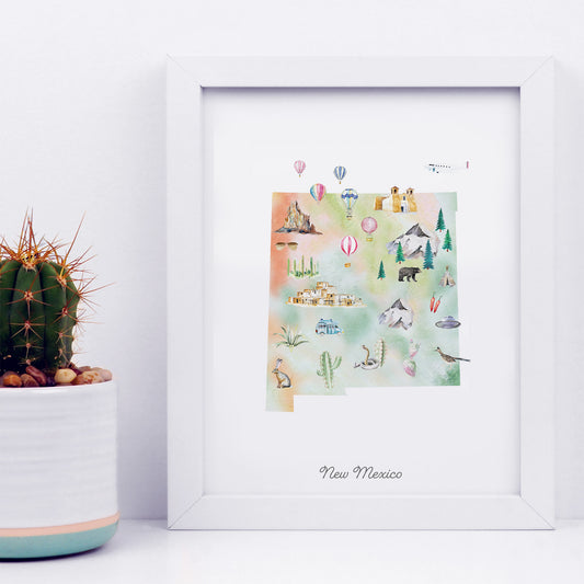 a framed watercolor illustration of New Mexico, with various landmarks and symbols such as mountains, cacti, and hot air balloons.