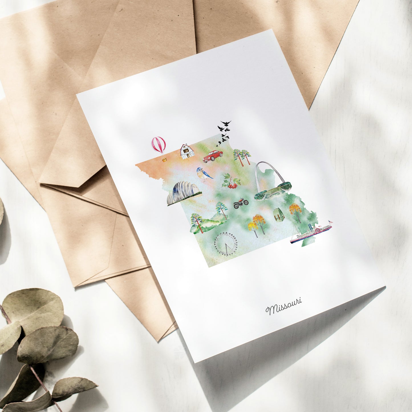 A greeting card featuring an illustration of various landmarks and symbols associated with the state of Missouri, including a hot air balloon, a state building, and a ferris wheel.