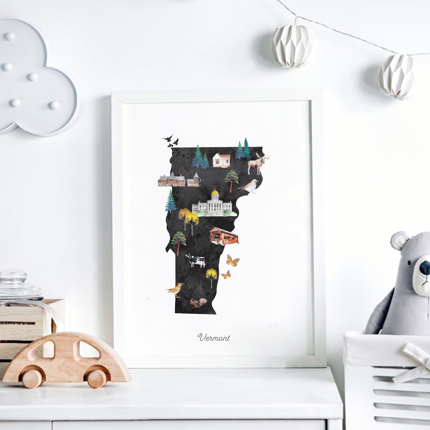 a framed illustration of the state of Vermont, with various landmarks and symbols representing the state's unique characteristics.
