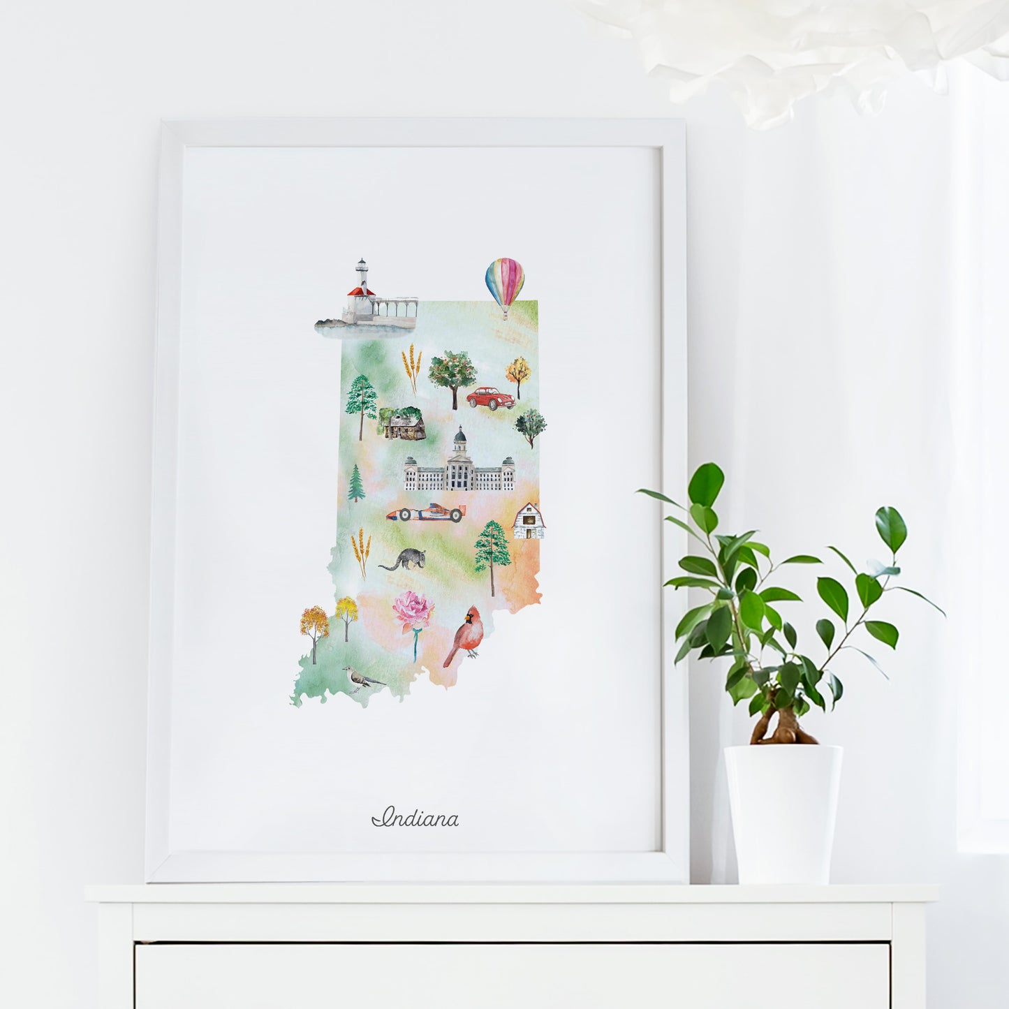 a framed watercolor illustration of the state of Indiana, with various landmarks and symbols representing the state's unique characteristics.