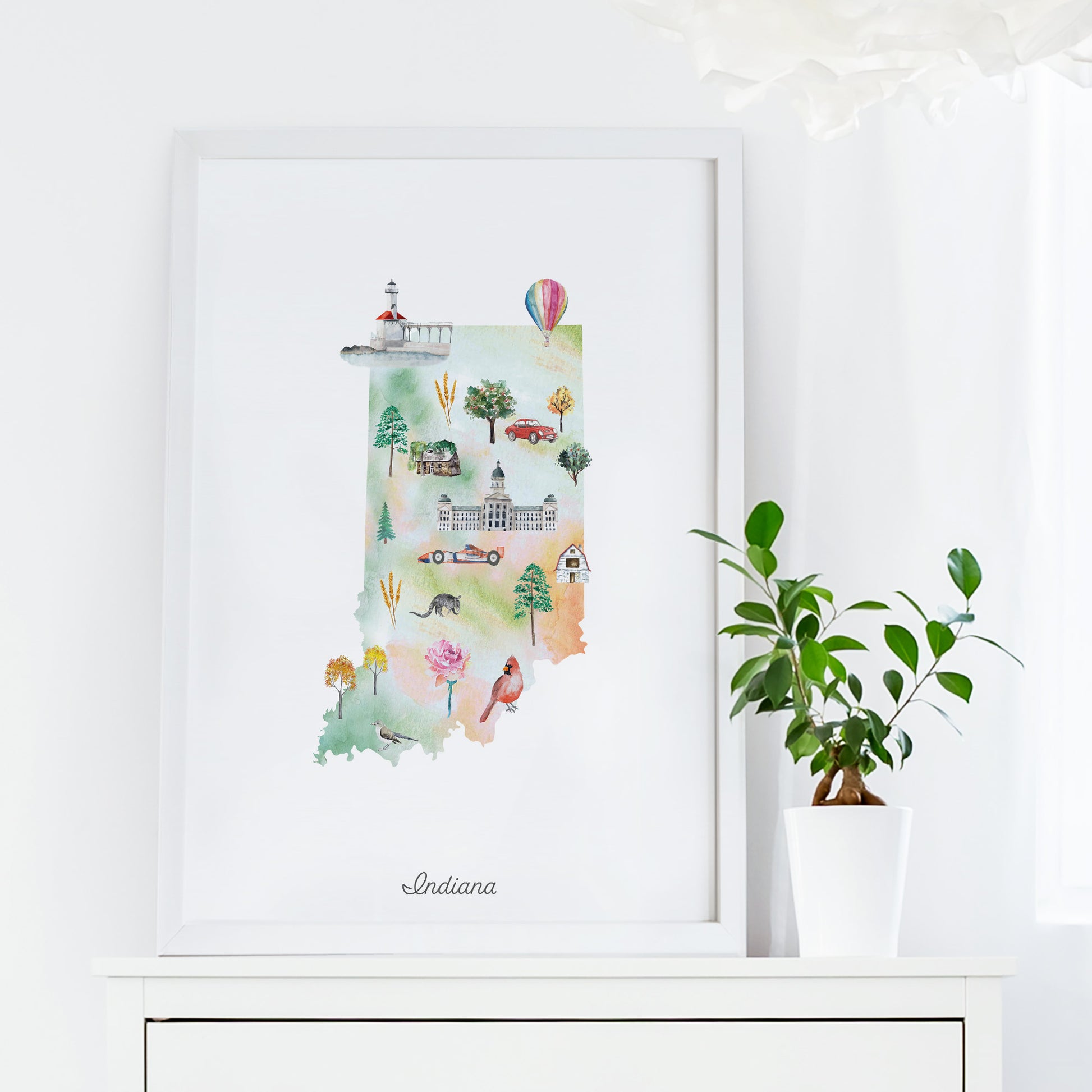 a framed watercolor illustration of the state of Indiana, with various landmarks and symbols representing the state's unique characteristics.