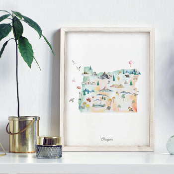 a framed watercolor illustration of the state of Oregon, with various scenes and landmarks depicted in a colorful and artistic manner.
