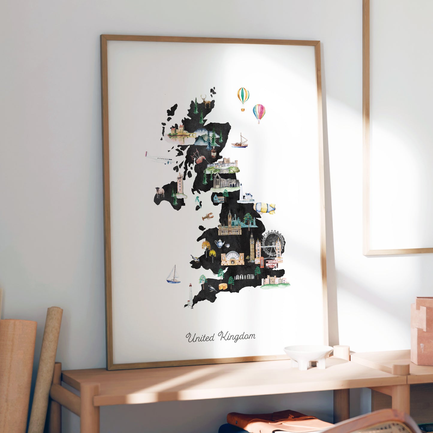a large framed map of the United Kingdom, with various landmarks and icons depicted on it.
