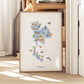 A framed watercolor map of Thailand, featuring various landmarks and symbols, is displayed on a wooden shelf.
